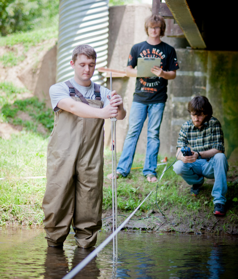 Graduate Students researching in a creek