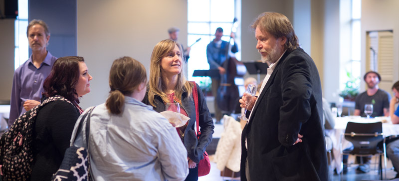students and faculty talking to an author at the 2016 literary festival