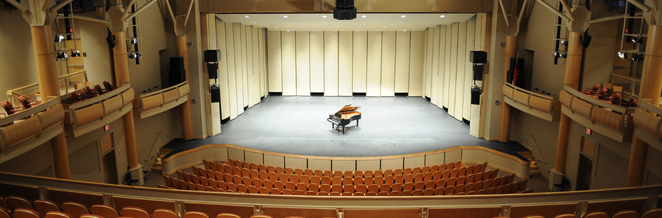 Photo of empty theatre with a grand piano on stage