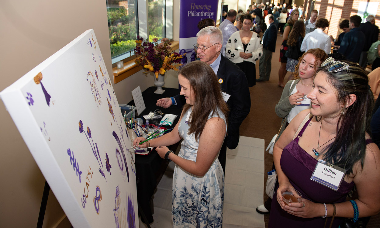 Students and donors add their own personal touches at an interactive paint station during the Scholars Showcase, signifying how they are making their mark on the university.